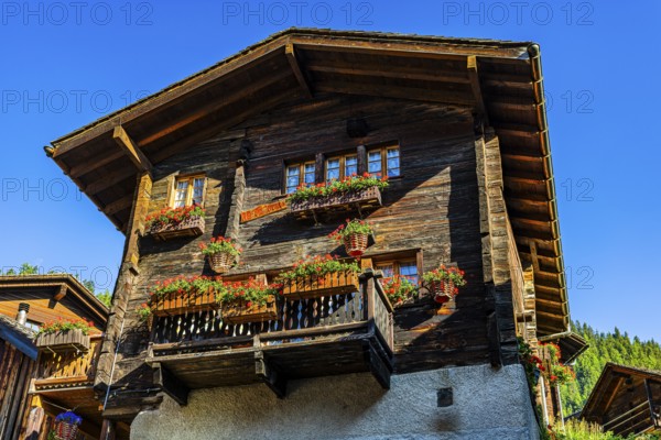Old wooden house in log construction, decorated with flowers, historic village centre, Grimentz, Val d'Anniviers, Valais Alps, Canton Valais, Switzerland
