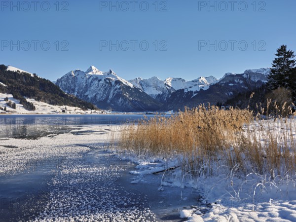 Frozen Sihlsee, reservoir, behind the snow-covered mountains Flübrig and Druesberg, Euthal, Canton Schwyz, Switzerland
