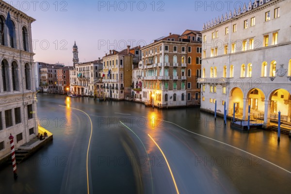 View of the Grand Canal at sunset, picturesque evening mood with illuminated palazzos on the canal and the church tower of the Chiesa Parrocchiale dei Santi Apostoli, long exposure, view from the Rialto Bridge, Venice, Veneto, Italy
