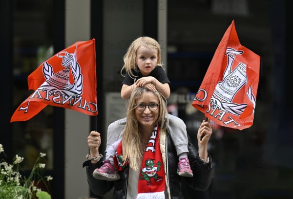 Woman, blonde, with girl, blonde, 4 years, sitting on shoulders, waving flags, flags of VfB Stuttgart, Cannstatt, can, scarf with mascot Fritzle, fans, smiling, Stuttgart, Baden-Württemberg, Germany
