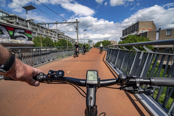 Ride over the Snelbinder Brug bicycle and pedestrian bridge, over the river Waal near Nijmegen, was built on the existing railway bridge, fast cycle path connection from the city centre of Nijmegen and the new housing estates in the Waalsprong district, Netherlands