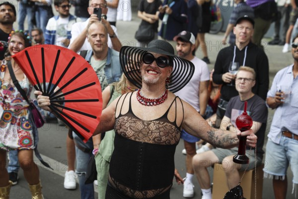 Man in net outfit with fan at the 47th Christopher Street Day under the motto Never again silent in Berlin on 26 July 2025