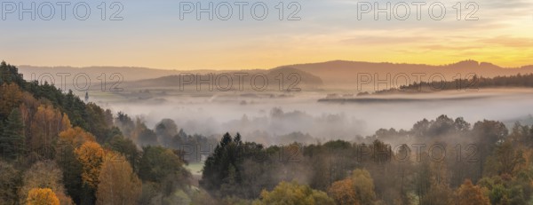 Landscape in Franconian Switzerland in autumn, view over colourful forests with morning mist at sunrise, Ahorntal, Franconian Switzerland, Upper Franconia, Bavaria, Germany
