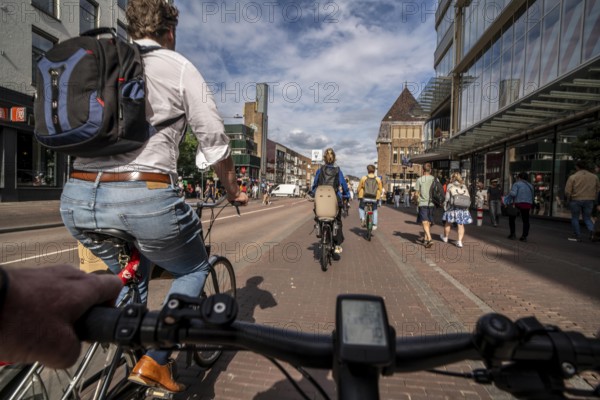 Ride your bike on the central cycle path on Lange Viestraat, Vredenburg, in the city centre of Utrecht, lanes for pedestrians, cyclists and public transport vehicles are separated, heavy cycle traffic, Netherlands
