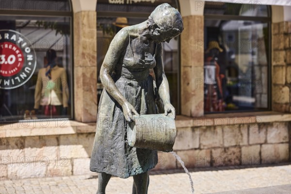 Mother and child fountain, sculptor Fritz Schelle, fountain with bronze sculptures, shop window, depth of field, sunlight, pedestrian zone, market square, Metzgerstraße, Berchtesgaden, Upper Bavaria, district of Berchtesgadener Land, Bavaria, Germany