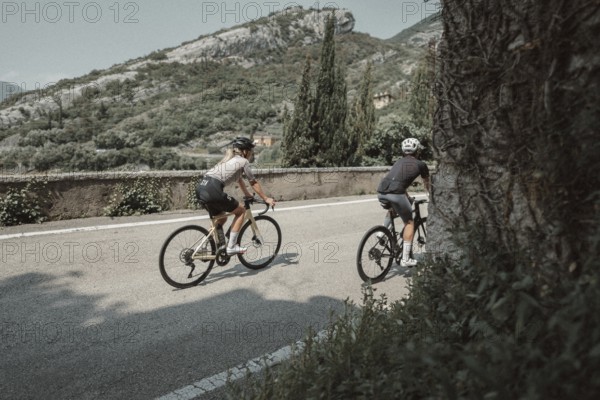 Woman and man cycling on Lake Garda in Italy. Sunny weather and dolce vita