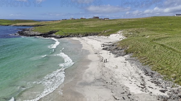 An idyllic coastal landscape with a sandy beach and green meadow under a blue sky, Meal Beach, Shetland Islands, Scotland, United Kingdom
