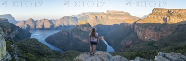Hiker enjoying panorama, sunset at Blyde River Canyon with Three Rondawels peak, view of canyon with Blyde River and table mountains in the evening light, canyon landscape, Panorama Route, Mpumalanga, South Africa