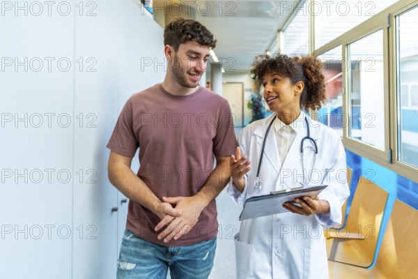 Doctor holding clipboard and explaining diagnosis to patient while walking in hospital corridor