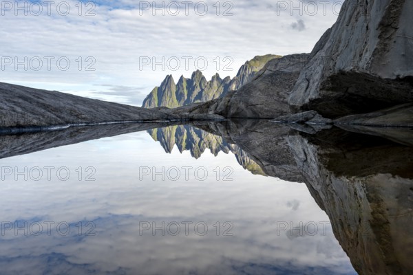 Reflection in a tidal pool, rocky coast of Tungeneset, Devil's Teeth, Okshornan, Ersfjorden, Senja Island, Troms, Norway
