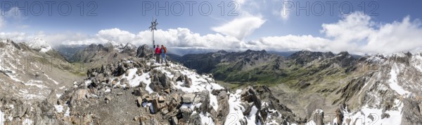 Mountain panorama, two female mountaineers at the summit of the Keeskopf with summit cross, behind them summit of the Petzeck, Hoher Perschitzkopf and Kruckelkopf, Kleiner Hornkopf, Schober group, Hohe Tauern National Park, Carinthia, Austria