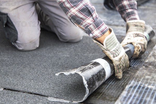 Roofers during waterproofing work with bitumen membranes
