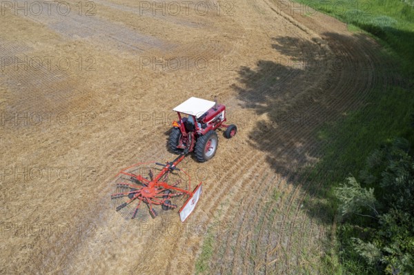 Wayland, Michigan - A farmer uses a rotary tedder to aerate his crop. A tedder spreads out hay or straw to allow quicker drying before baling