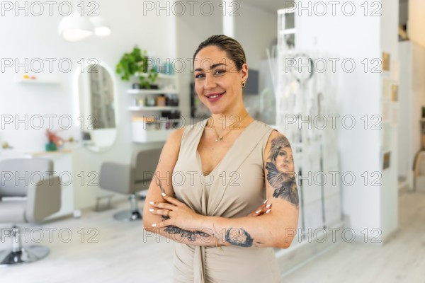 Portrait of a smiling hairdresser standing with arms crossed in her modern beauty salon, proud small business owner