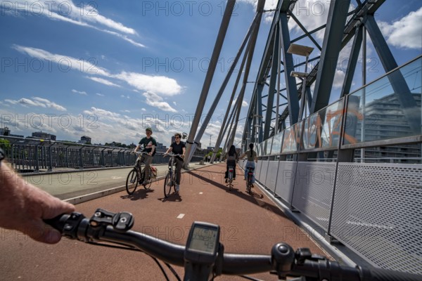 Ride over the Snelbinder Brug bicycle and pedestrian bridge, over the river Waal near Nijmegen, was built on the existing railway bridge, fast cycle path connection from the city centre of Nijmegen and the new housing estates in the Waalsprong district, Netherlands