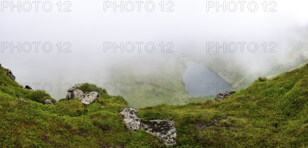 Wisps of mist drift over Kaltenbachsee, Schladminger Tauern, Sölktäler nature park Park, St. Nikolei, Styria, Austria
