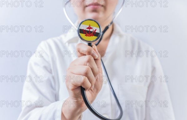 Female doctor holding stethoscope with Brunei flag. National health system of Brunei
