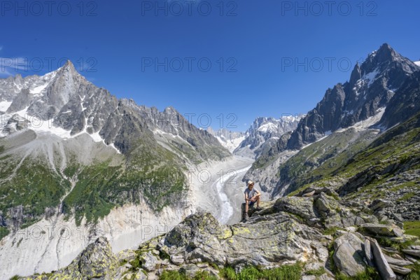 Picturesque mountain landscape with imposing mountain peaks and glaciers, mountaineer on hiking trail, Grand Balcon Nord, glacier tongue Mer de Glace, behind Grandes Jorasses, Mont Blanc massif, Montenvers, Chamonix, Haute-Savoie, France