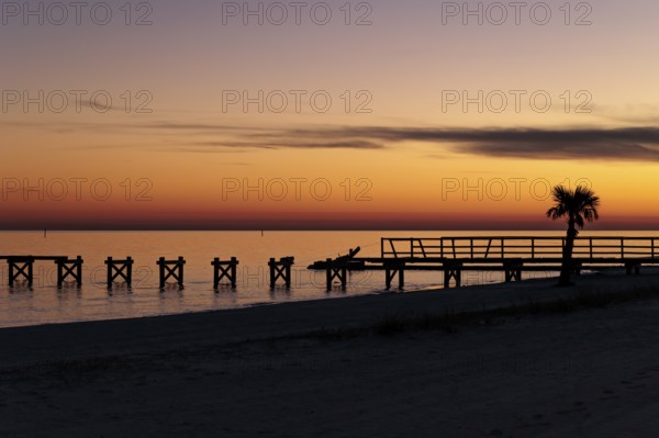 Sunset behind dilapidated fishing pier damaged by hurricanes on the Mississippi Gulf Coast in Long Beach, Mississippi
