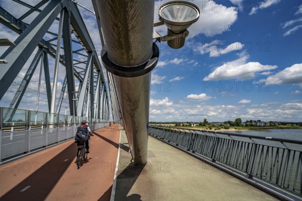 Cycle and pedestrian bridge Snelbinder Brug, over the river Waal near Nijmegen, was added to the existing railway bridge, fast cycle path connection from the city centre of Nijmegen and the new housing estates in the Waalsprong district, Netherlands
