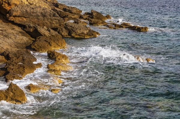 Rugged rocky coastline and foaming spray, on Stecci beach, near Capoliveri, Elba Island, Tuscan Archipelago National Park, Tuscany, Italy