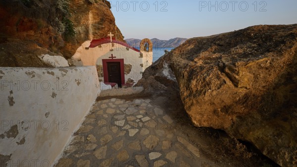 Legend, crab, shell fisherman, stone path to the chapel on the coast, surrounded by rocks, with calming sea view in the evening light, chapel, little church, Agia Kavouradena monastery, Xirokambos, Leros, Dodecanese, Greek Islands, Greece