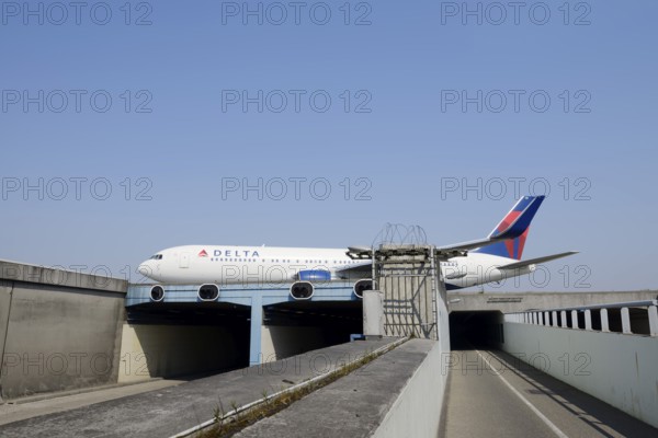 Aeroplane taxiing over a bridge over a road and cycle path, Amsterdam-Schiphol Airport, North Holland, Netherlands