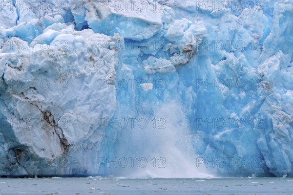 Collapsing ice wall of Fjortende Julibreen, 14th of July Glacier calving into Krossfjorden, Haakon VII Land, Spitsbergen, Svalbard, Norway