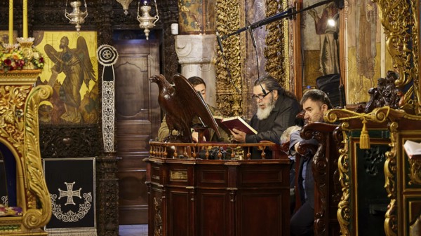 Men reading from religious books in a church decorated with icons, Holy Week, Bay of Panormitis, Panormitis Monastery, Symi, Dodecanese, Greek Islands, Greece