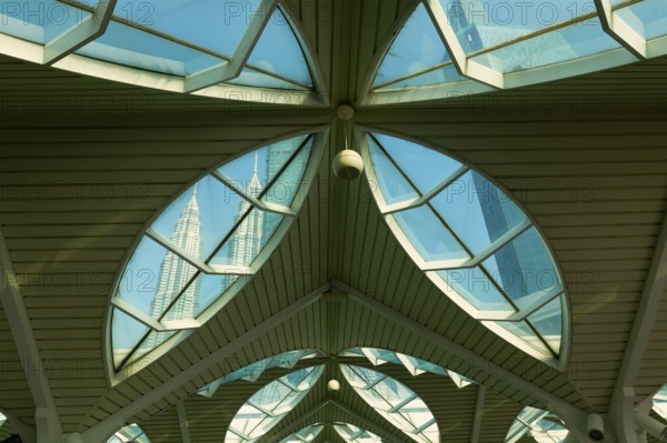Petronas twin towers viewed through glass roofs of As Syakirin Mosque or KLCC Mosque, Kuala Lumpur, Malaysia, Asia