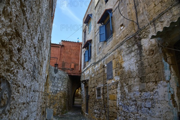 Winding old alleyway with stone façade and blue shutters in historic surroundings, Rhodes Old Town, Rhodes, Dodecanese, Greek Islands, Greece