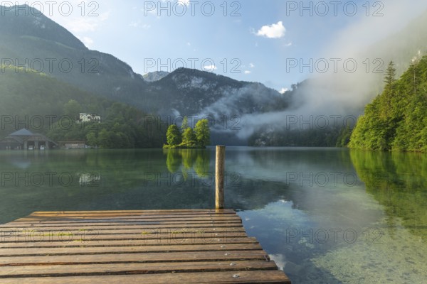 Mystical morning at Königssee in Schönau with boathouses and Christlieger. Sunrise and beautiful wafts of mist over the Königssee in the basin