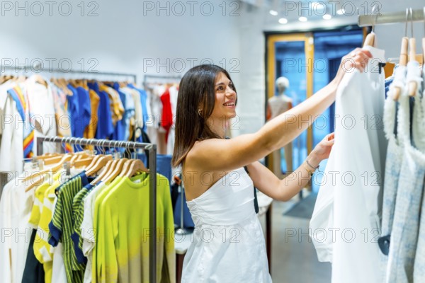 Smiling customer browsing colorful clothes on hangers in a vibrant fashion retail store, enjoying a delightful shopping experience
