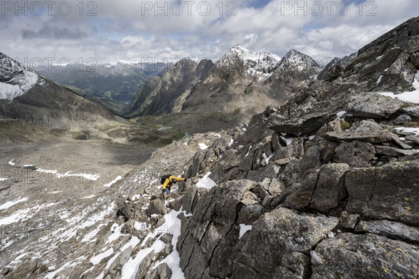 Mountaineer in rocky mountain landscape, descent from the summit of Keeskopf, behind summit of Petzeck, Hoher Perschitzkopf and Kruckelkopf, Schober group, Hohe Tauern National Park, Carinthia, Austria