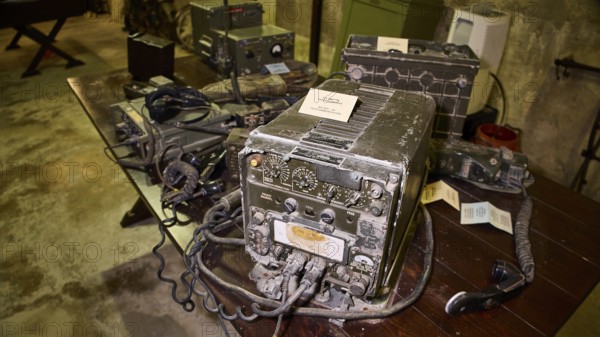 A pile of antique radios on a dark wooden table in a bunker, War Museum, Military Museum, Tunnel Museum, Lakki, Leros, WW2, Dodecanese, Greek Islands, Greece