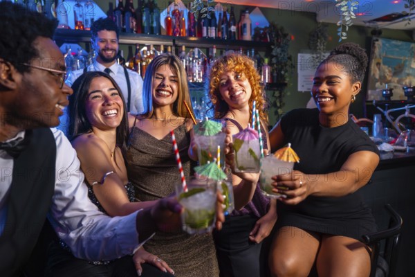 Cheerful group of friends raising glasses of mojito cocktails, enjoying nightlife at a vibrant bar