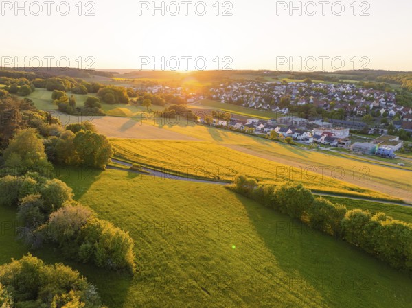 Village at sunset with wide green fields and trees, Gechingen, Black Forest, Germany