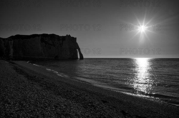 Beach, pebble beach, rock arch Falaise or Porte d'Aval, Étretat, sea, steep coast, cliffs, chalk cliffs, alabaster coast, La Côte d'Albâtre, backlight, silhouette, sunset, evening mood, black and white, Normandy, Seine-Maritime, France