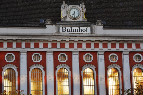 Hamm main station, façade with station clock and sculptures of a wire-drawer and a miner at the station building, North Rhine-Westphalia, Germany