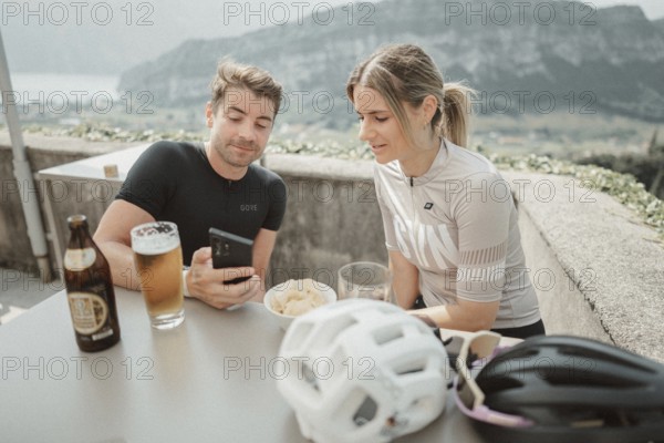 Woman and man cycling on Lake Garda in Italy. Sunny weather and dolce vita