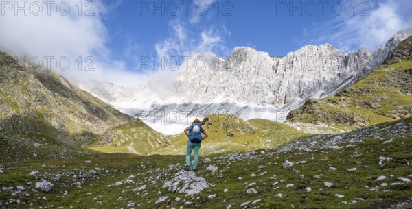 Mountaineer in mountain landscape, rocky mountain peaks of the Moarer Weißen in the background, Seven Lakes Hike, Stubai Alps, near Ridnaun, South Tyrol, Italy
