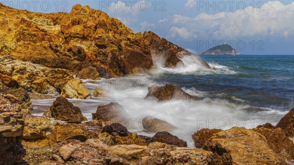 Rugged rocks and foaming spray on Topinetti beach, near Rio Marina, Elba Island, Tuscan Archipelago National Park, Tuscany, Italy
