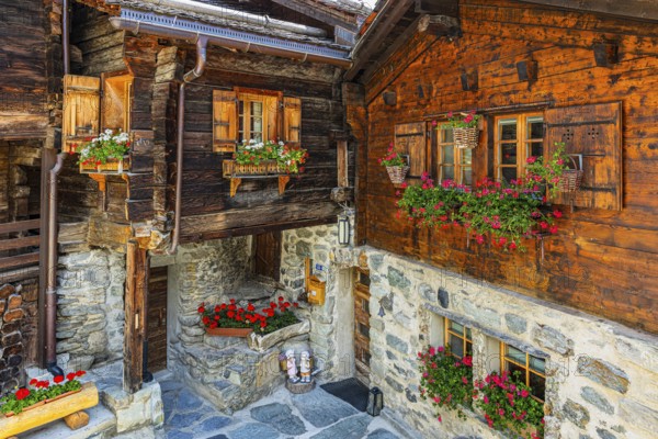 Old wooden houses in log construction, decorated with flowers, historic village centre, Grimentz, Val d'Anniviers, Valais Alps, Canton Valais, Switzerland