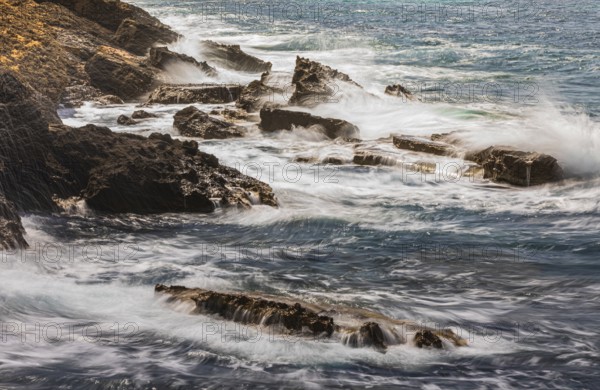 Rugged rocky coastline and foaming spray, on Stecci beach, near Capoliveri, Elba Island, Tuscan Archipelago National Park, Tuscany, Italy