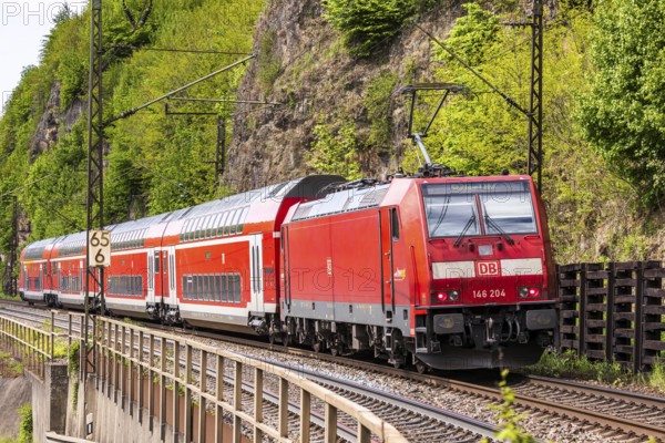 Regional express RE5 en route on the winding railway line of the Geislinger Steige. Landscape along the railway line in spring. Amstetten, Baden-Württemberg, Germany