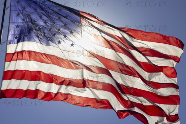 Dramatic backlit american flag waving in the wind