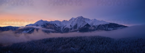 Spectacular sunrise with purple sky over misty mountains, Canton of Grisons, Switzerland