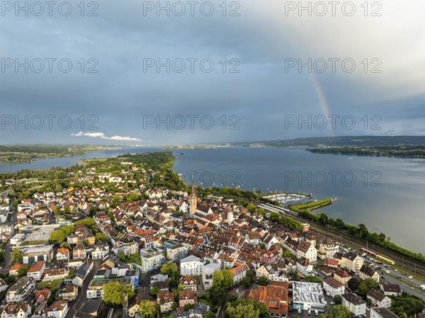 Luftbild von der Stadt Radolfzell am Bodensee mit der historischen Altstadt und dem Radolfzeller Münster nach einem Gewitterschauer von der Abendsonne angestrahlt, am Horizont ein Regenbogen, Landkreis Konstanz, Baden-Württemberg, Deutschland