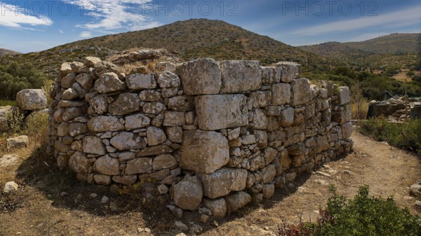 Sky exchanged, Large stone wall in an unspoilt mountain landscape with cloudy sky and surrounded by vegetation, Artemis Temple, Artemis, Diana, goddess of the hunt, altar. Church, tower, near the airport in the north of the island, Leros, Dodecanese, Greek Islands, Greece