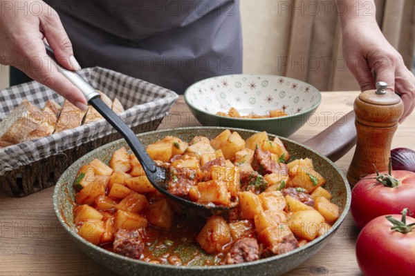 Homemade stew with potatoes and meat, cooked in a frying pan, is served on a plate
